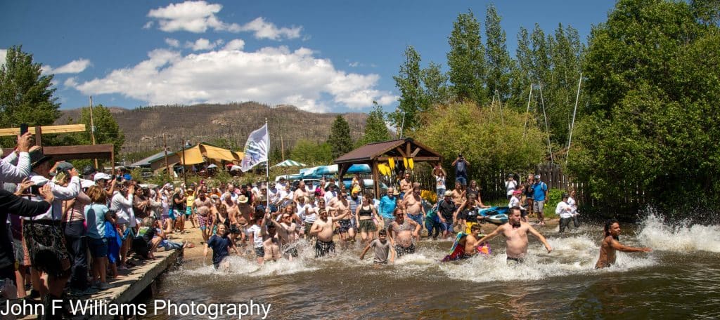 People participate in outdoor event by the water, "John F Williams Photography"