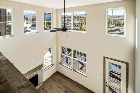 Modern living room with large windows and ceiling fan