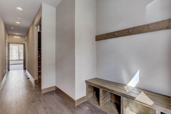 Hallway with hardwood floors and wood bench with hooks