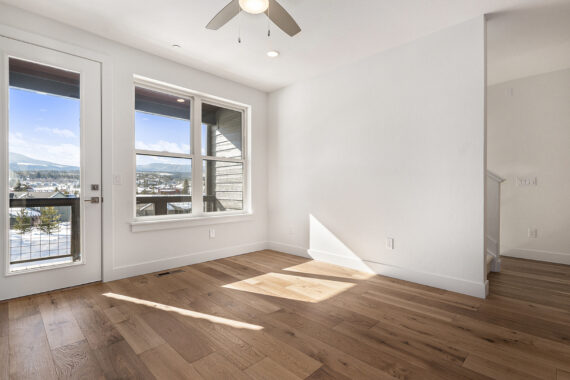 Bright empty room with wood floors and large windows