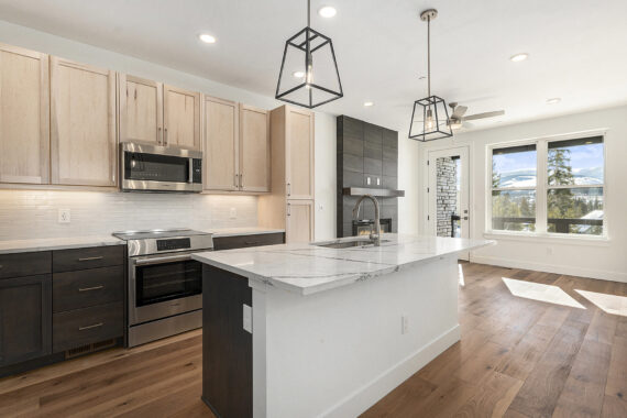 Modern kitchen with island, stainless steel appliances, wood flooring