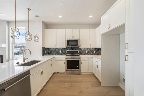 Modern kitchen with white cabinets and stainless steel appliances