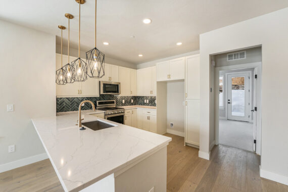 Modern kitchen with quartz countertops and geometric pendant lights