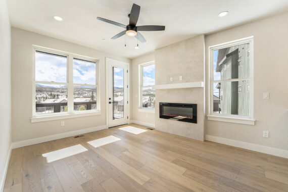 Modern room with large windows, hardwood floor, and fireplace