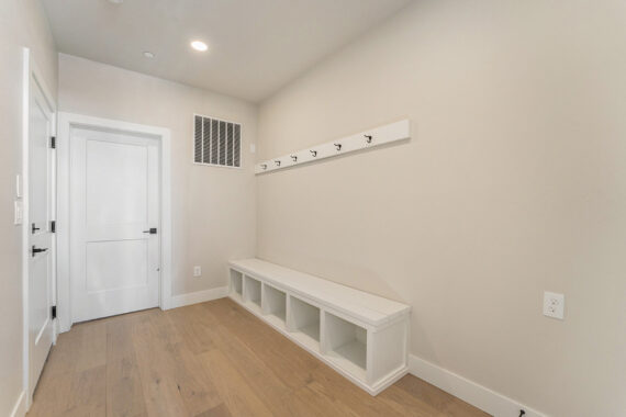 Room with bench, cubbies, and coat hooks