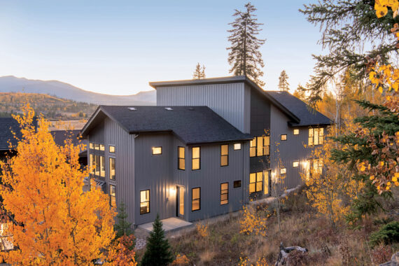 Modern house surrounded by autumn foliage and mountains