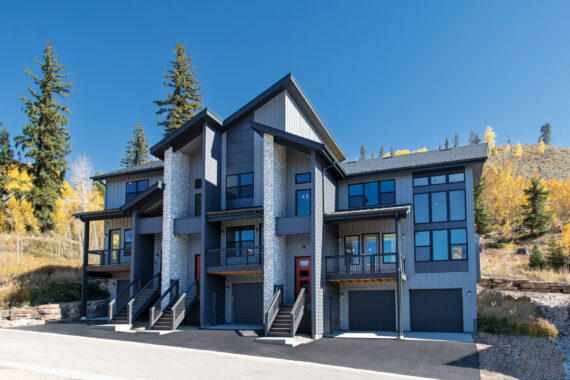 Modern townhouse complex with mountains and trees in background