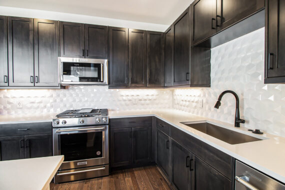 Modern kitchen with dark cabinets and white countertops