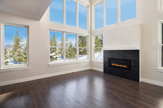 Living room with large windows and a fireplace.