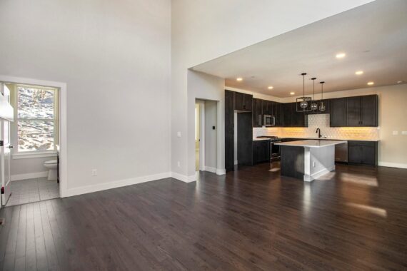 Open space with dark wood floors, modern kitchen, and adjacent bathroom