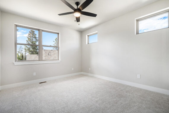 Empty room with beige carpet and ceiling fan