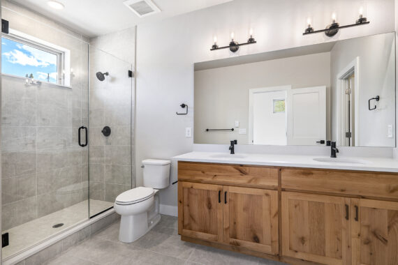 Modern bathroom with glass shower, wooden vanity, large mirror