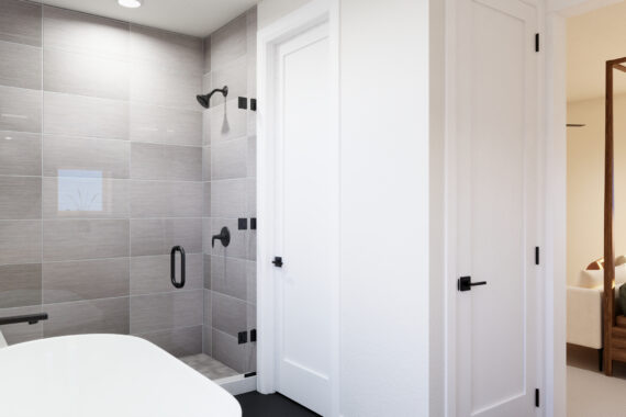 Modern bathroom with bathtub, shower, and adjacent bedroom.