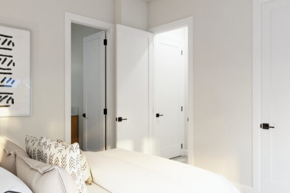 Bedroom with white doors, abstract art, and patterned pillows