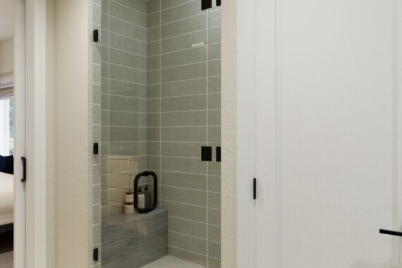 Shower area with glass door next to a bedroom