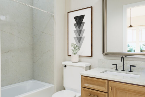 Bathroom with wooden cabinet, framed art, and mirror.